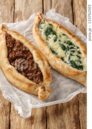 Turkish Pide pizzas with minced meat and cheese with spinach close-up. Vertical 119762005