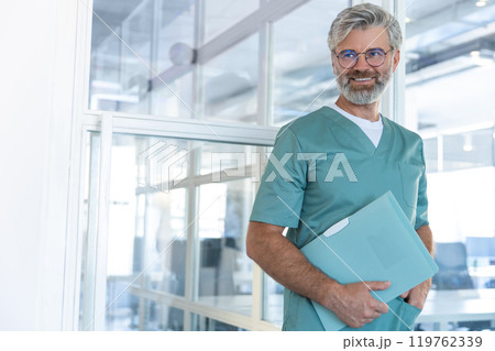 Good-looking gray-haired bearded male doctor in lab coat smiling nicely 119762339