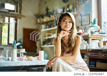 Portrait of young beautiful woman posing in craft workshop Portrait of young beautiful woman posing in craft workshop 119762667