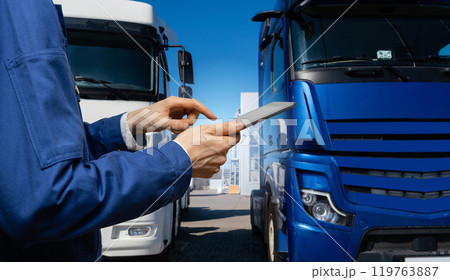 Fleet manager with digital tablet on a background of trucks Fleet manager with digital tablet on a background of trucks 119763887