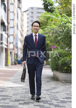 街を歩く笑顔の30代後半のビジネスマン　　全身 119764697