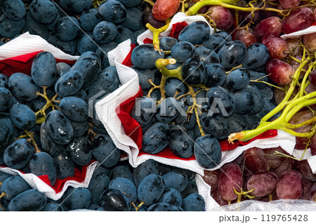 Blue and red sweet grapes on boxes in supermarket, top view. 119765428