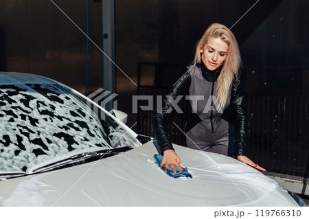Female driver washing car at car wash 119766310
