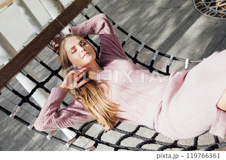 Beautiful fashion woman rides on a swing 119766361