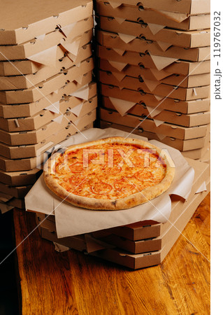 Stacked pizza boxes with a fresh pizza, ready for delivery or takeaway 119767032