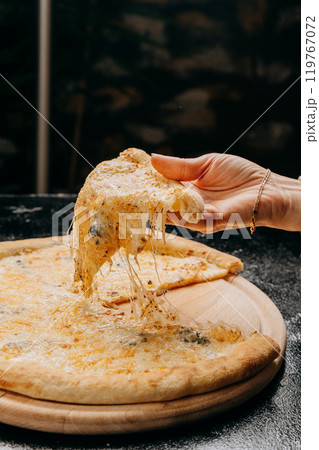 Melting cheesy pizza slice being lifted, showcasing gooey cheese pull, perfect for pizza lovers 119767072