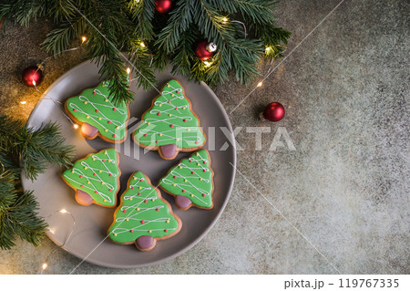 Christmas tree shaped gingerbread. Top view of plate with christmas cookies on gray background with copy space 119767335
