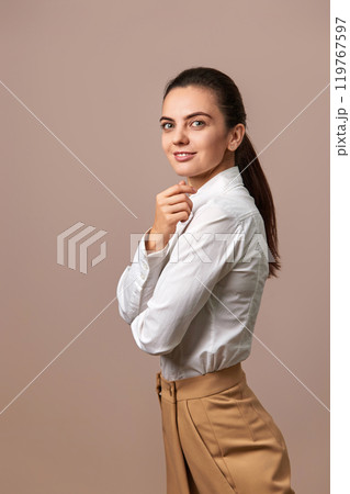 caucasian businesswoman lady with crossed arms in white shirt and beige pants 119767597