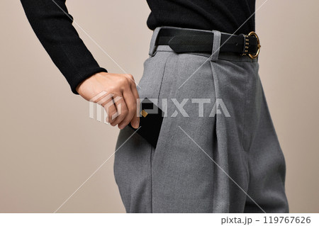 female hand putting black premium credit bank card in pants pocket. Money finance female hand putting black premium credit bank card in pants pocket. Money finance 119767626