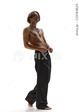 Shirtless young man tilts his head back, showing carefree, intense energy against white studio background. Shirtless young man tilts his head back, showing carefree, intense energy against white studio background. 119769629