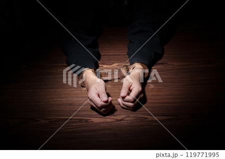 手錠を掛けられた男性 119771995