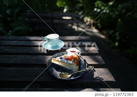 blue coffee cup and Dessert with coffee  Strawberry Cheesecake on grunge wooden table outdoor chilling 119772363
