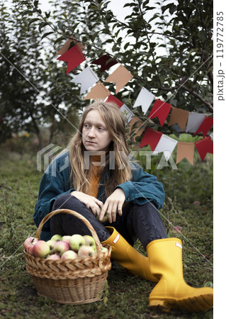 girl holds basket with juicy apples in the garden girl holds basket with juicy apples in the garden 119772785