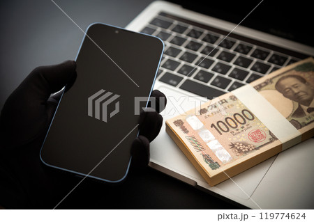 お金を盗む犯罪者の手とスマホとパソコン お金を盗む犯罪者の手とスマホとパソコン 119774624
