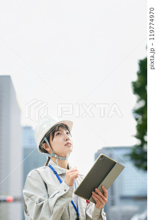 作業服とヘルメットを着用した若い女性 作業服とヘルメットを着用した若い女性 119774970