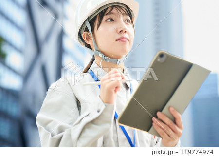 作業服とヘルメットを着用した若い女性 作業服とヘルメットを着用した若い女性 119774974