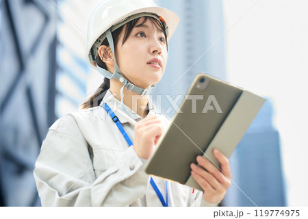 作業服とヘルメットを着用した若い女性 作業服とヘルメットを着用した若い女性 119774975