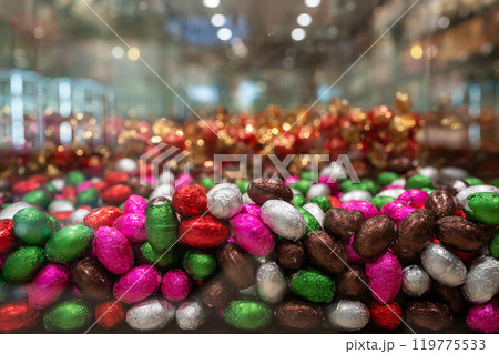Lots of candies in colorful packages on the shop window. Colored candy in the form of eggs. Lots of candies in colorful packages on the shop window. Colored candy in the form of eggs. 119775533