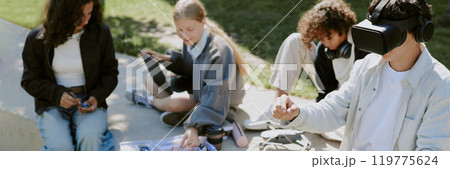 Website banner with boy playing VR game while his biracial friends building robots in background Website banner with boy playing VR game while his biracial friends building robots in background 119775624