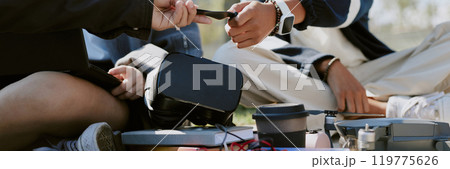 Website banner with two unrecognizable friends helping each other with drone 119775626