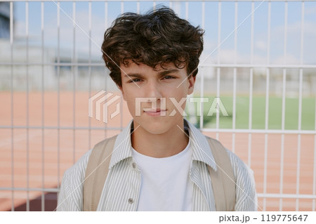Medium close up of curly haired Caucasian teen boy dressed in casual clothes Medium close up of curly haired Caucasian teen boy dressed in casual clothes 119775647