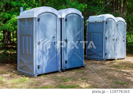 Long row portable bio of chemical toilets cabins in park center at city 119776163