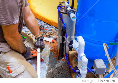 Water supply pipe made of PVC is being connected to pump house of an artesian well system 119776176