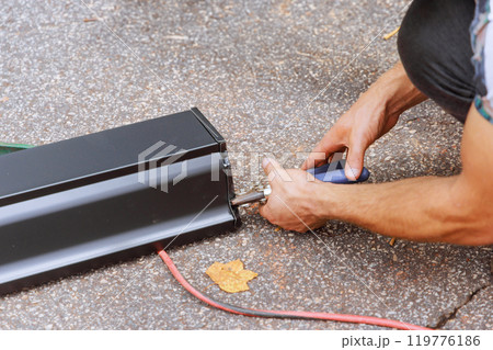 Worker cuts aluminum rain gutters with shears after they have been bent on machine Worker cuts aluminum rain gutters with shears after they have been bent on machine 119776186