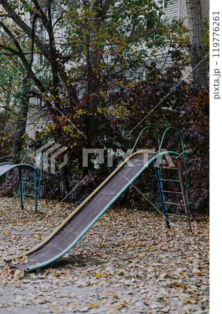 Old unsafe metal multi-colored children's slide. Equipment in kindergarten. Old unsafe metal multi-colored children's slide. Equipment in kindergarten. 119776261