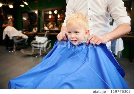 Adorable kid excited about new haircut. Little boy first time in barbershop. Cute client waiting for hairdresser. Adorable kid excited about new haircut. Little boy first time in barbershop. Cute client waiting for hairdresser. 119776305