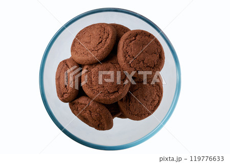 Chocolate cookies in a clear glass bowl isolated on white background, top view. Chocolate cookies in a clear glass bowl isolated on white background, top view. 119776633