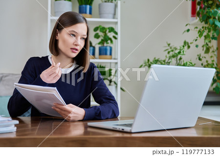 Young female college student studying using laptop computer for video chat Young female college student studying using laptop computer for video chat 119777133