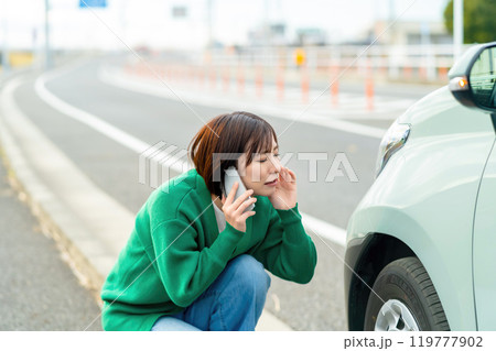 車のトラブルで電話する女性　自動車事故で困る女性 119777902