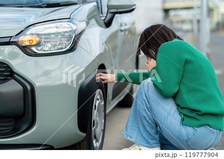 車のトラブルで電話する女性　自動車事故で困る女性 119777904