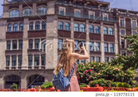 Female tourist in the central square of Mexico City, Zocalo. Cultural exploration, travel, and historic architecture concept 119778115