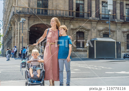 Mother, baby son and teenage son tourists in the central square of Mexico City, Zocalo. Family travel, cultural exploration, and historic architecture concept 119778116
