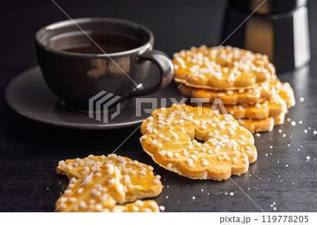 Sweet cookies in the shape of a flower. Tasty biscuits on black table. Sweet cookies in the shape of a flower. Tasty biscuits on black table. 119778205