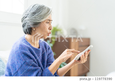 スマートフォンを操作するシニア女性 119778390