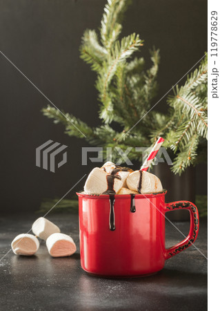 Mug of hot chocolate and cacao with marshmallows with christmas fir tree branches on black background. Xmas holiday. Mug of hot chocolate and cacao with marshmallows with christmas fir tree branches on black background. Xmas holiday. 119778629