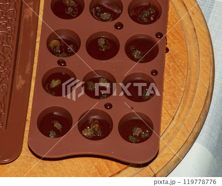 Silicone molds for shaping chocolate and sweets are filled with hot chocolate to cool. Silicone molds for shaping chocolate and sweets are filled with hot chocolate to cool. 119778776