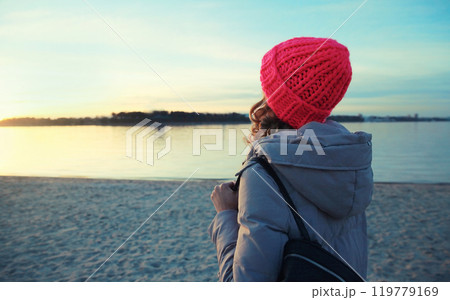 Travel, adventure, traveler woman on the beach looking at sunset, enjoying landscape, on sea coast 119779169