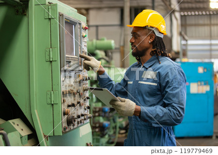 Male african american workers wear yellow hard hat holding wrench working on repairing factory machinery. man maintenance Factory, mechanical repairman concept. 119779469