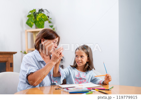 Grandmother giving high five to girl holding Grandmother giving high five to girl holding 119779915