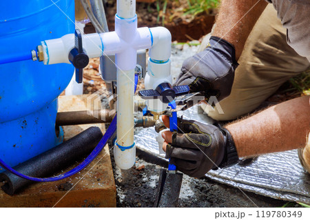 PVC water pipe is being connected to pump house for artesian well system PVC water pipe is being connected to pump house for artesian well system 119780349