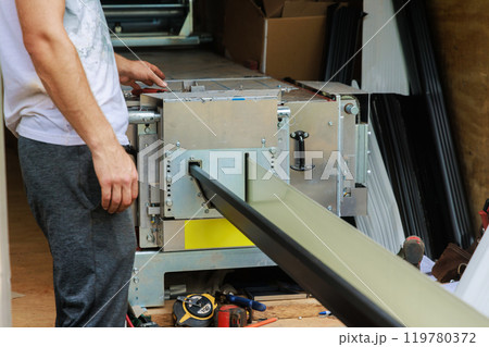 Bending thin metal rain gutters is performed with bending machine 119780372