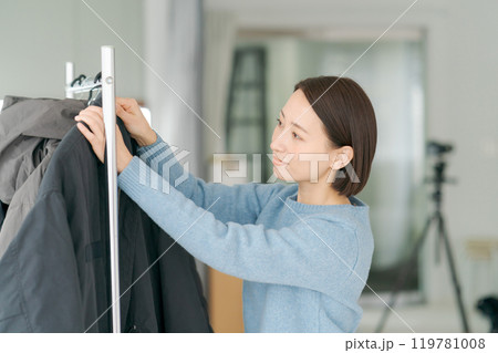 洋服をハンガーにかける女性 119781008