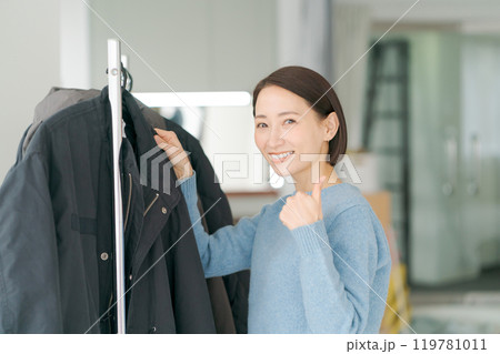 洋服をハンガーにかける女性 119781011