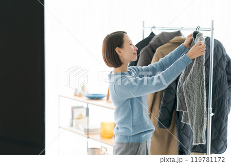 洋服をハンガーにかける女性 119781172