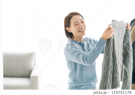 洋服をハンガーにかける女性 119781176