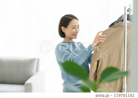 洋服をハンガーにかける女性 119781182